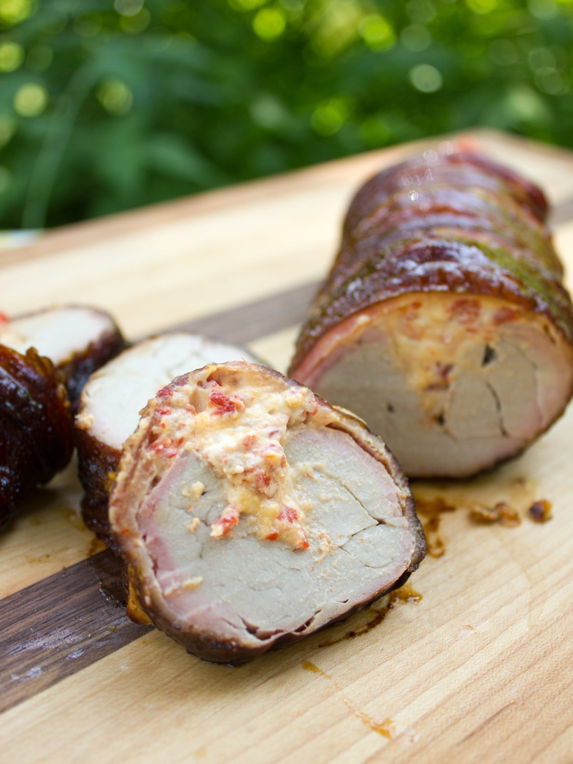 Bacon wrapped smoked pork tenderloin with roasted red pepper and cheese stuffing