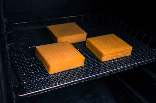 Cheddar cheese on a smoker rack